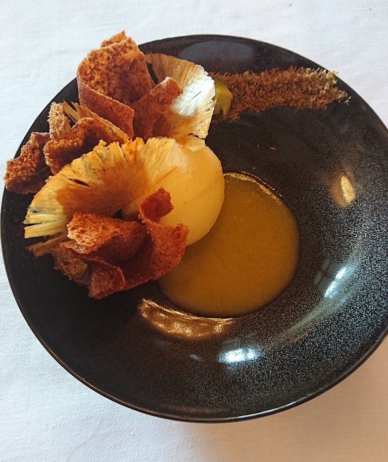 Crée par le chef pâtissier Cédric Grolet, ce dessert affiche sa légèreté avec une sensation de sucre quasi inexistante. En bref, un petit p^éché mignon que l'on peu s'accorder sans frustration. Dessert: chips d'ananas, crémeux et jus d'ananas chaud, avocat, piment d'Espelette_© Clémence Rouyer