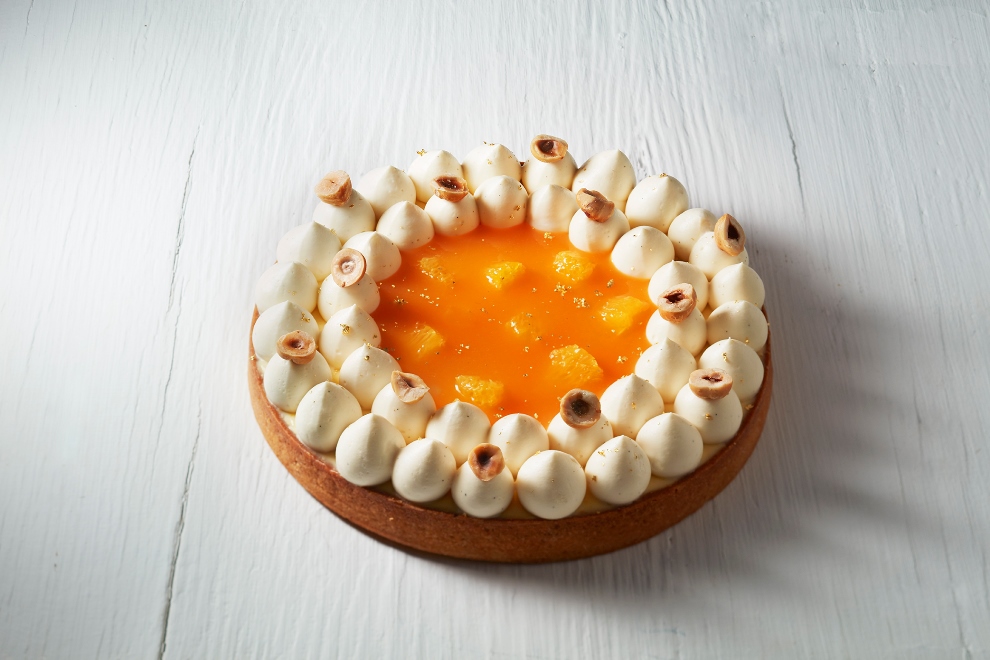 Tarte orange-noisette: Pâte sucrée craquante, crème d’amande à la noisette, compotée à l’orange, crème à la fleur d’oranger et suprêmes d’orange frais.