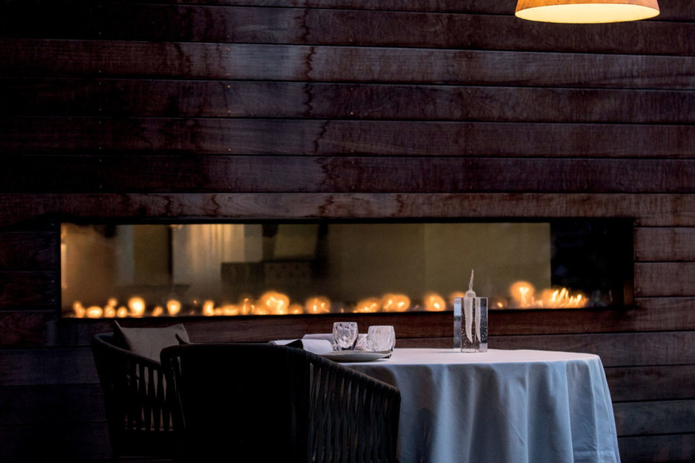 Matériaux bruts pour ambiance délicate dans la toute nouvelle salle de restaurant. Sur les murs, le bois noircit à mesure qu’il s’approche des fl ammes. Celle des fourneaux, celle de la passion qu’entretiennent le chef et son équipe.