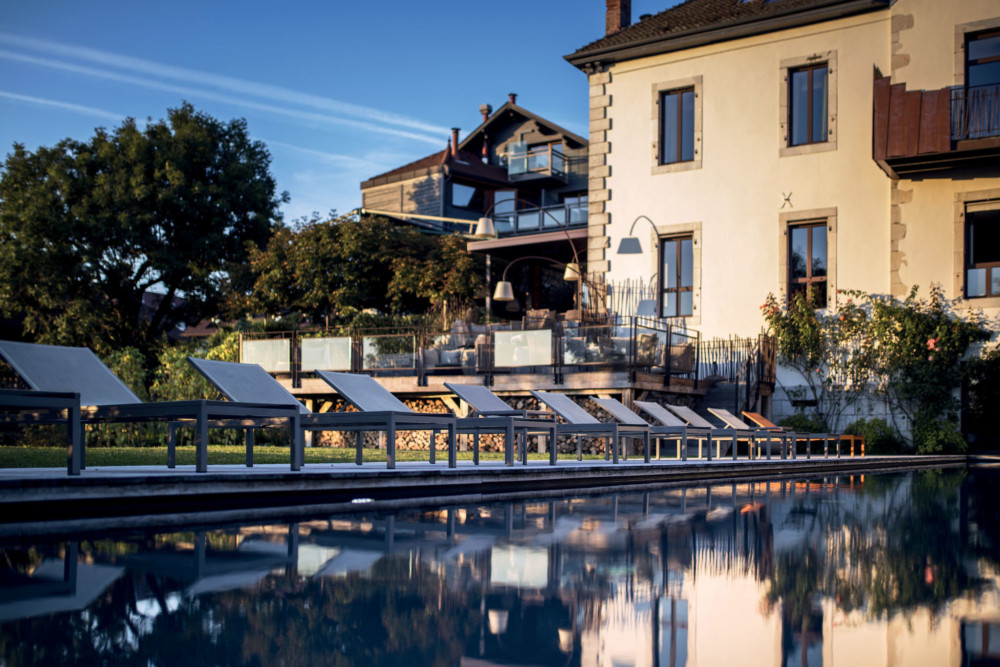 Plus qu’un hôtel-restaurant, le Clos des Sens est un refuge douillet pensé dans les moindres détails. Dès l’entrée, l’oeil se pose irrésistiblement sur un parterre de plantes aromatiques où l’on peut apercevoir un commis ramasser quelques brins avant le service. À l’intérieur, la décoration moderne n’est pas dépourvue d’âme et a le bon goût de ne pas être à la mode. Pour passer la nuit, dix chambres toutes plus singulières les unes que les autres se disputent le sommeil des gens de passage. Certaines avec des cheminées, d’autres avec d’immenses baignoires à remous. Une invitation à la paresse, et à la luxure…