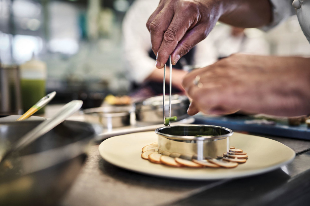 Des gestes minutieux de dressage en cuisine chez Régis Marcon