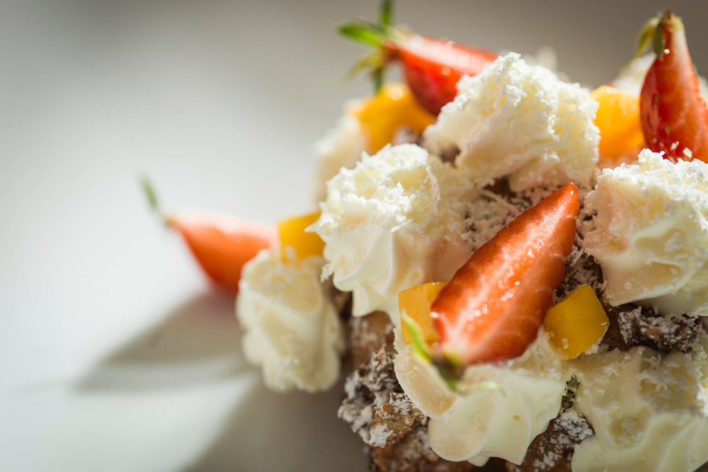 Un chou croûté de noisettes, crème glacée au jus de fraise, chair de mangue & crème montée