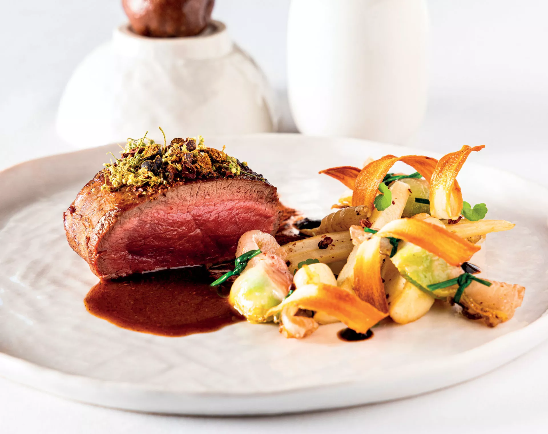 Dos de cerf, salsifis et bonbons de choux de Bruxelles au lard, jus cacaoté, infusé aux baies de genévrier