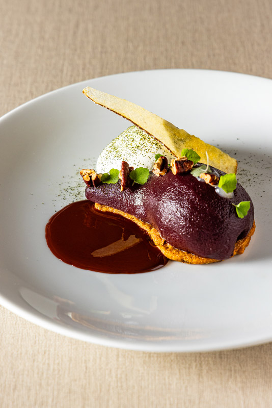 La poire pochée au vin rouge épicé, crumble aux amandes et  sauce chocolat Manjari